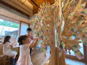 平和のメッセージツリーにメッセージを飾る子ども