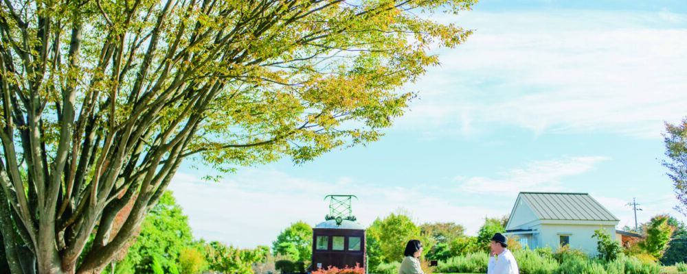 安曇野ちひろ公園のベンチでふたりが向かい合って座っている写真。