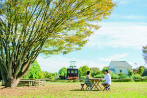 安曇野ちひろ公園のベンチでふたりが向かい合って座っている写真。