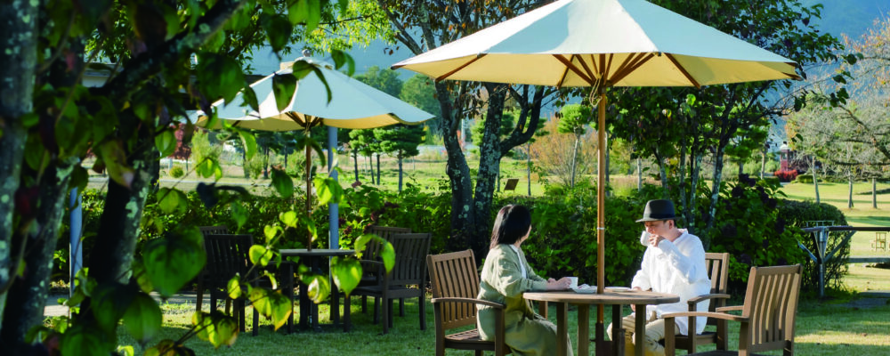 絵本カフェのテラス席で、大人ふたりが食事をしている写真